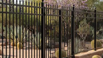 Black ornamental metal fence with decorative design by Chop Chop Landscaping in Tucson, AZ